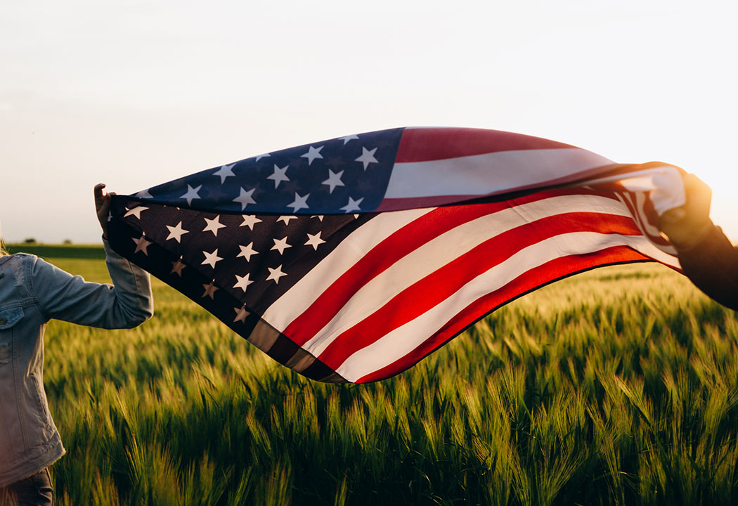 two people holding an American flag